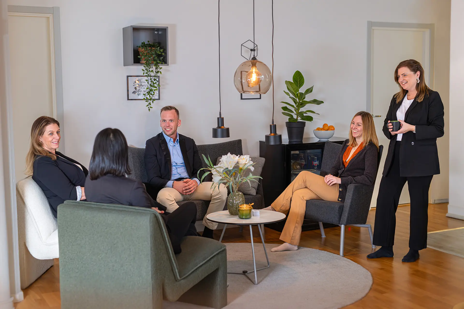 5 personer sitter i en soffa och fikar